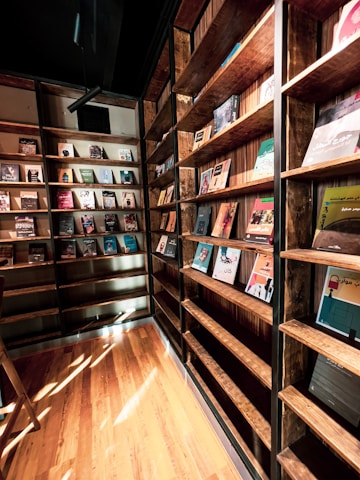A cozy library corner with shelves full of diverse books and a warm reading lamp.
