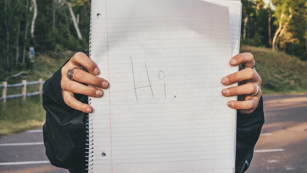 person holding white ruled paper