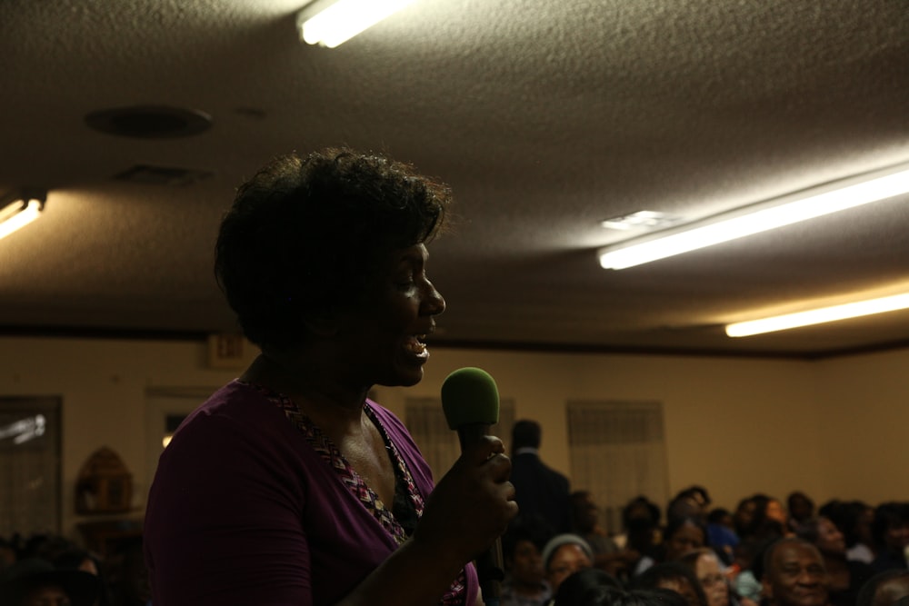 woman in purple dress holding microphone