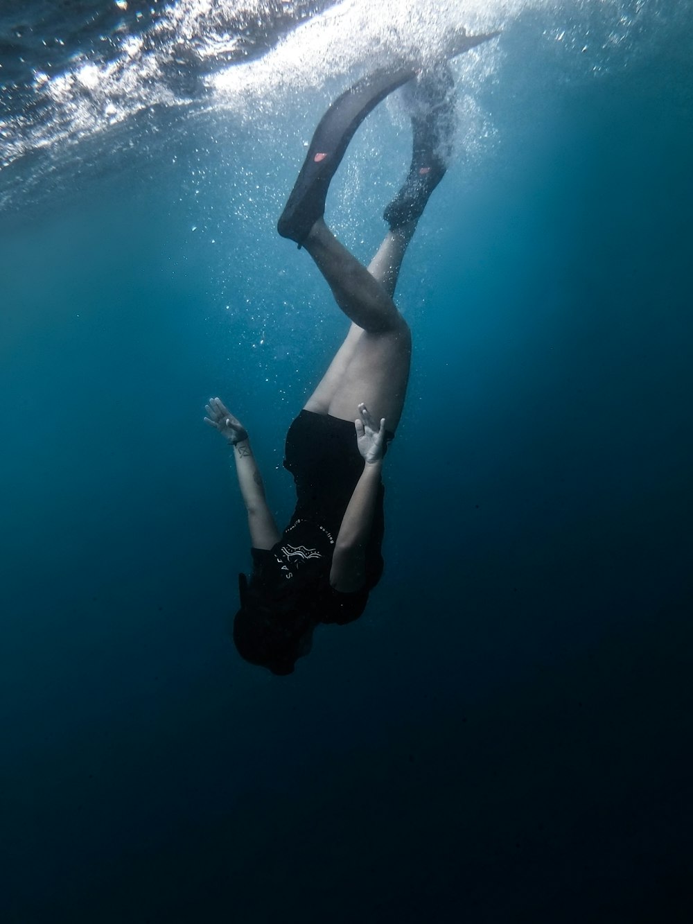 person in black shorts under water