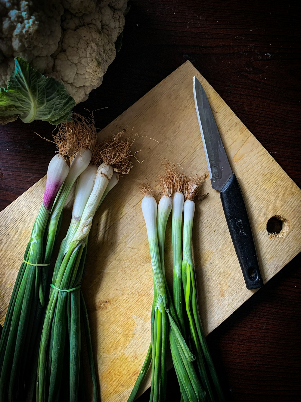 茶色の木製のまな板に緑と白の野菜