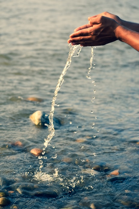 person holding water splash during daytime