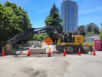 yellow and black heavy equipment near green trees during daytime