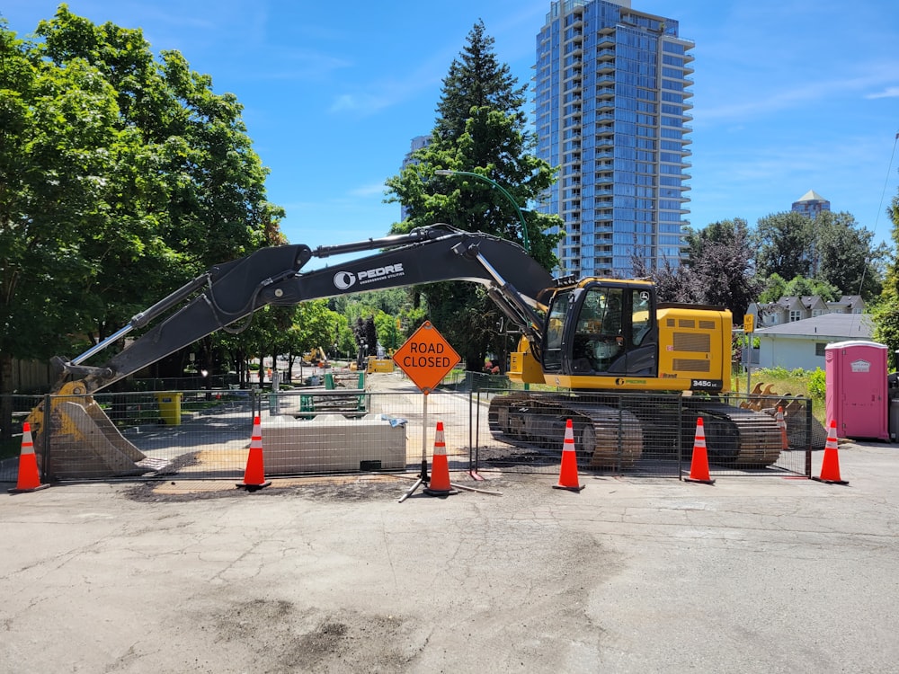 yellow and black heavy equipment near green trees during daytime