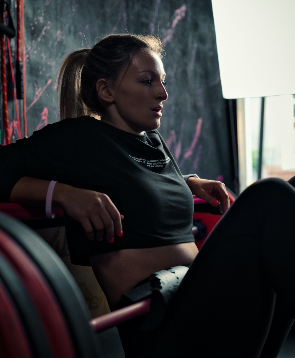 woman in black long sleeve shirt sitting on red and black chair