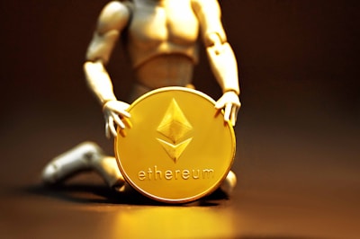 A figurine kneels and holds a large gold coin featuring the Ethereum logo and text. The background is dark, highlighting the coin's metallic sheen.