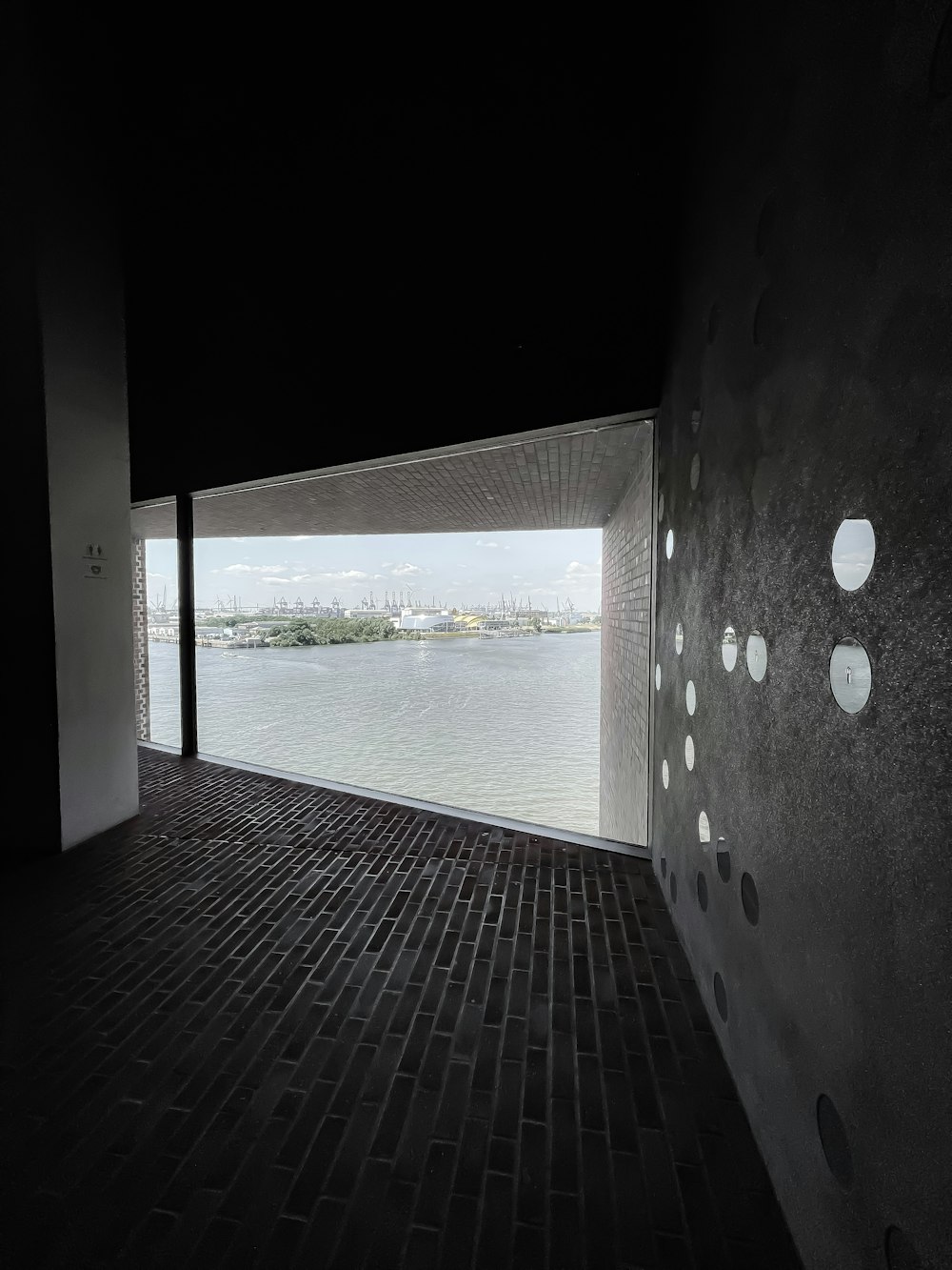 Edificio de hormigón blanco y negro cerca del cuerpo de agua durante el día