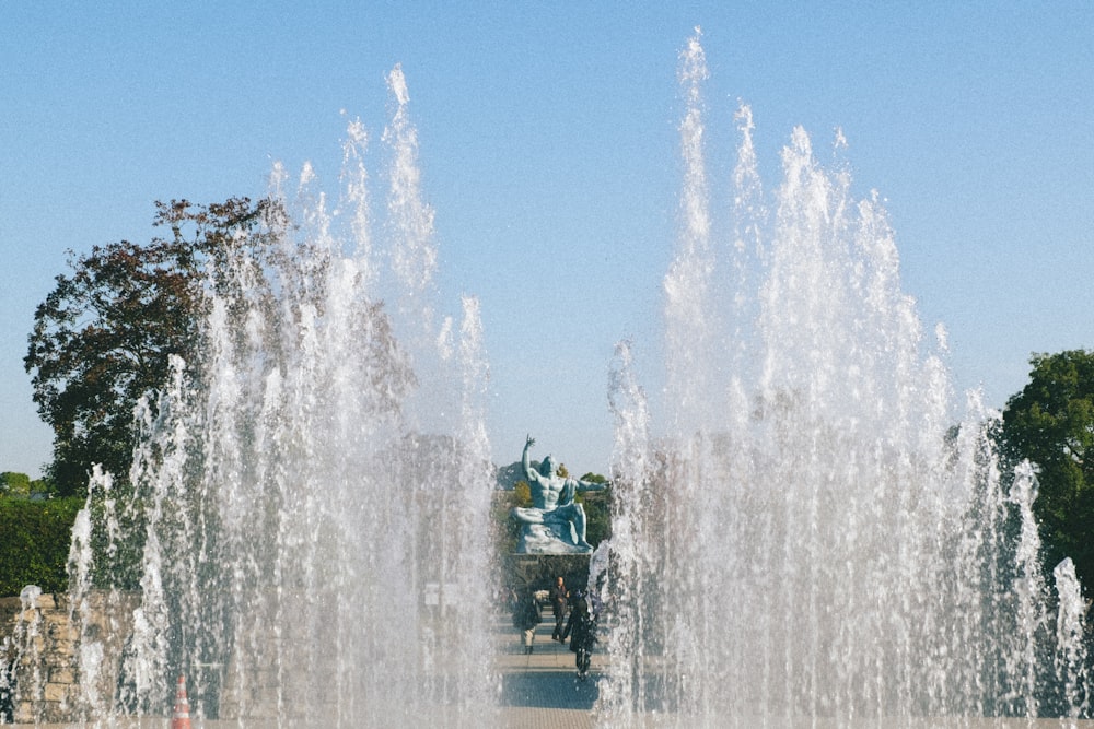 people sitting on water fountain during daytime