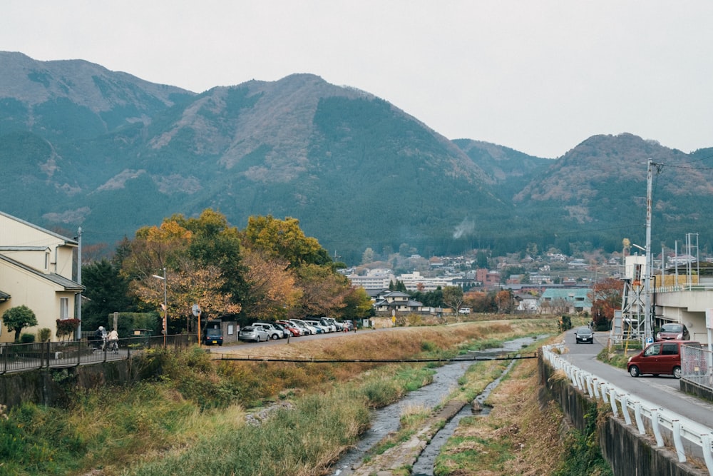 昼間の白い空の下に緑と茶色の山