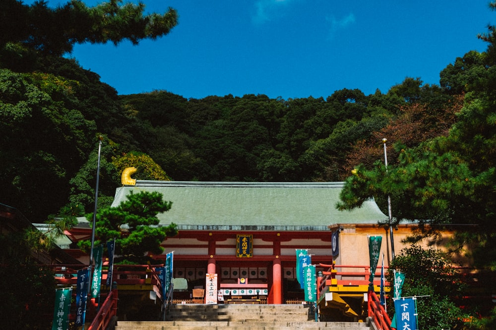 red and white wooden building near green trees during daytime