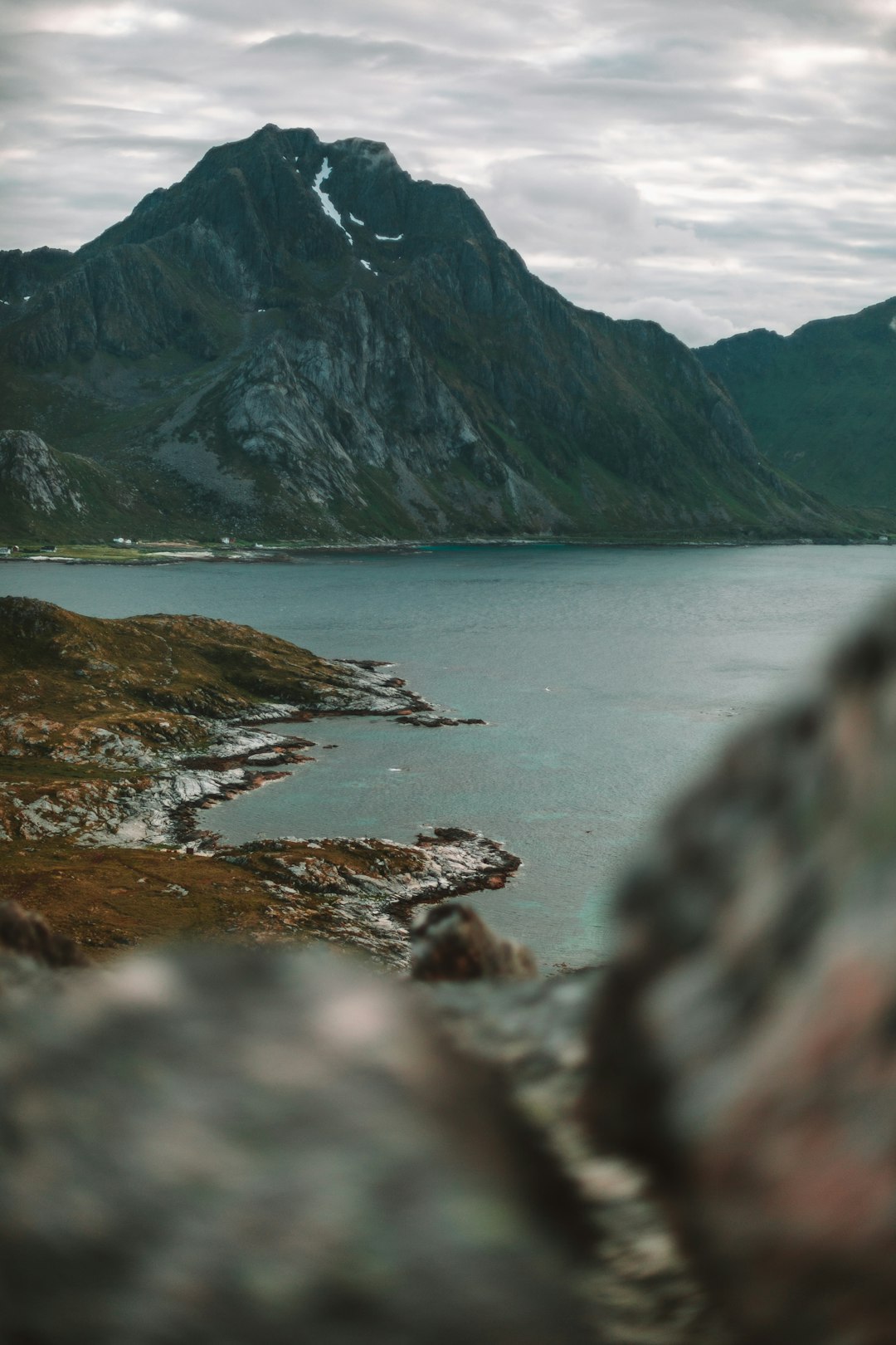 body of water near mountain during daytime