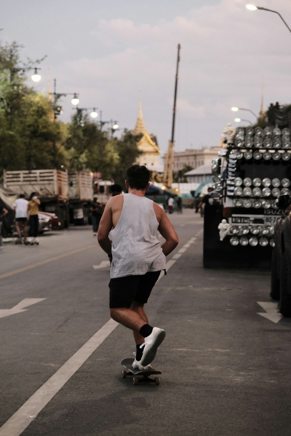 man in white tank top and black shorts running on road during daytime