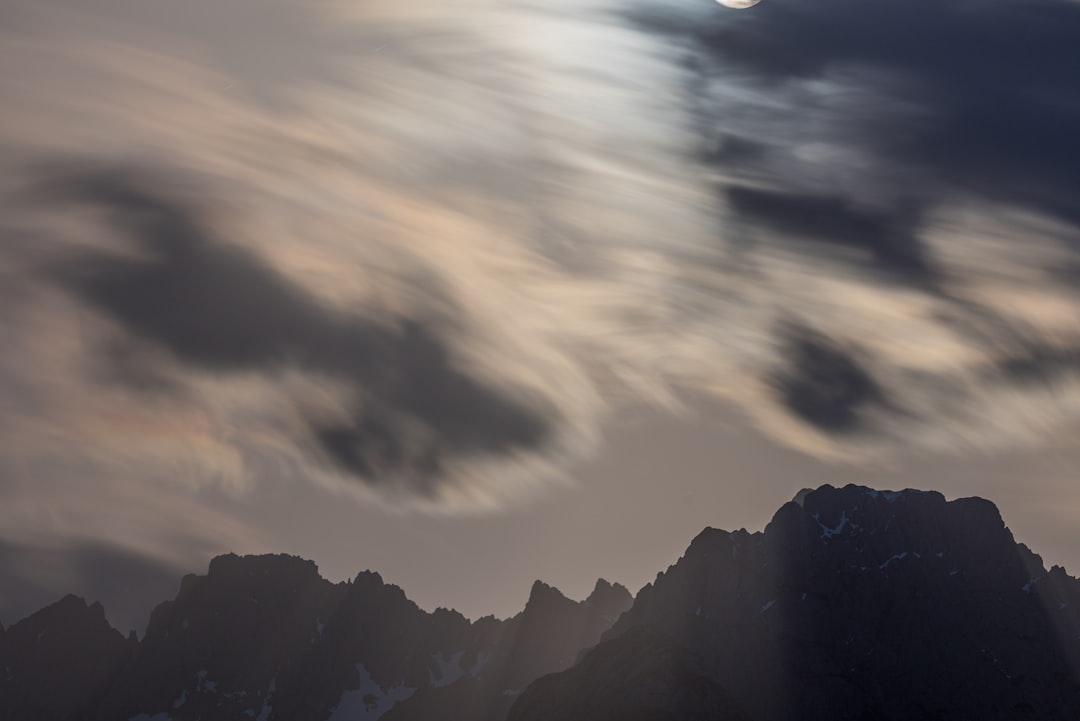 silhouette of mountain under cloudy sky during daytime