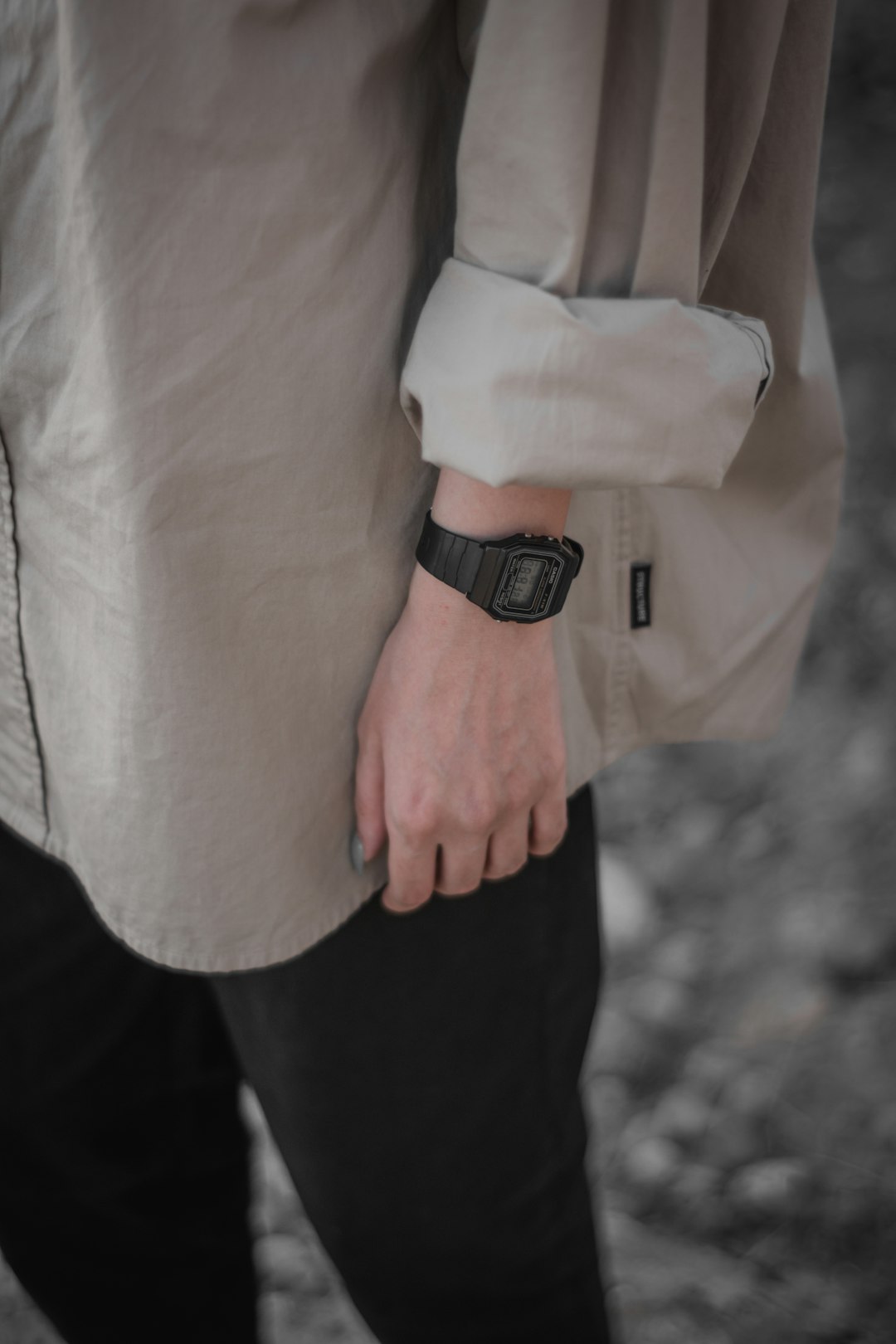 person in pink dress shirt and black pants wearing black leather strap watch