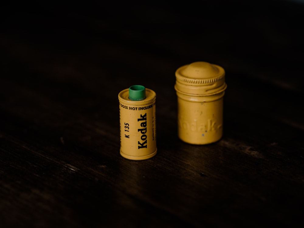 2 yellow plastic bottles on brown wooden table