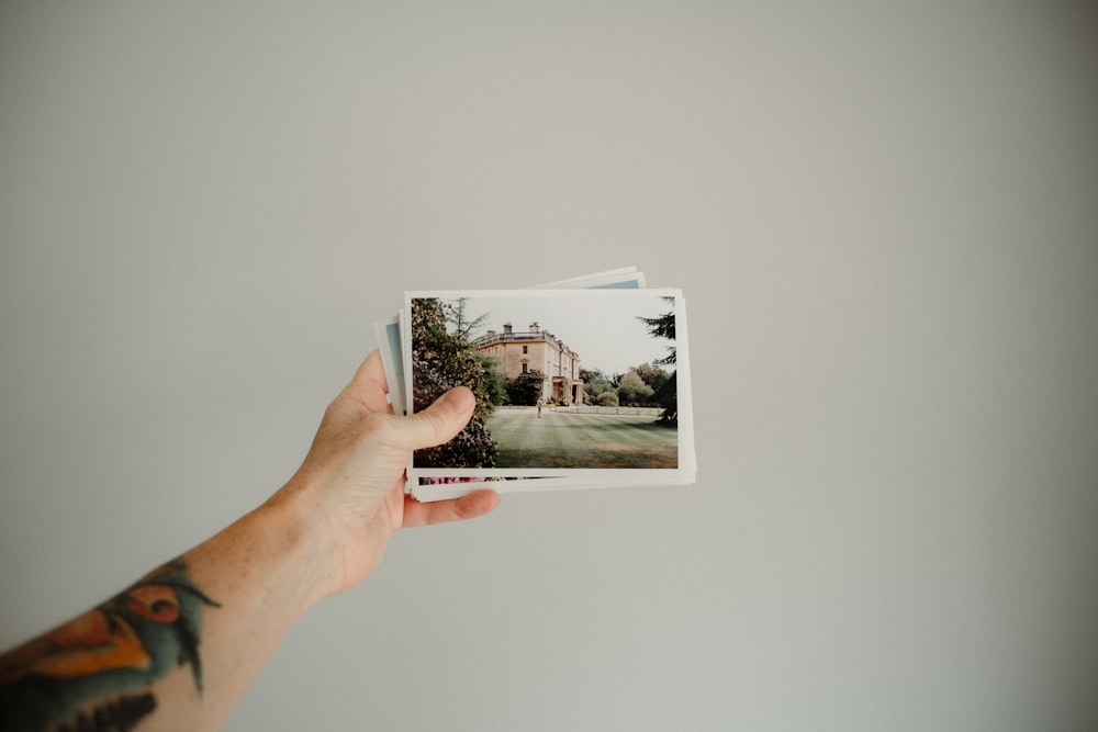 personne tenant une photo de la maison