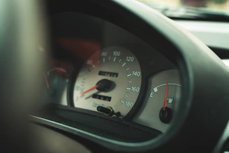 A close-up of a fuel gauge needle pointing near full on a car dashboard.