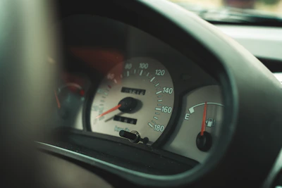 A close-up of a fuel gauge needle pointing near full on a car dashboard.