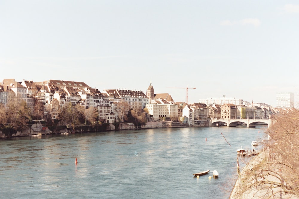 people riding on boat on river near buildings during daytime