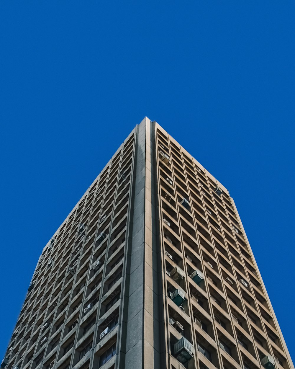 Niederwinkelaufnahme eines grauen Betongebäudes unter blauem Himmel tagsüber