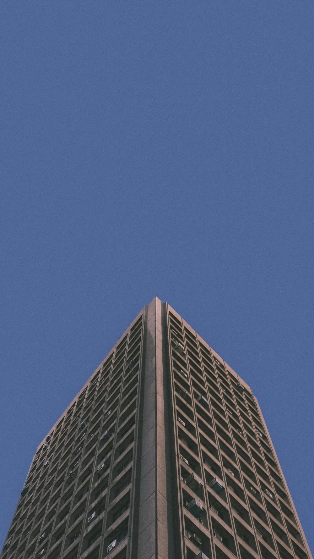 Edificio de hormigón marrón bajo el cielo azul durante el día