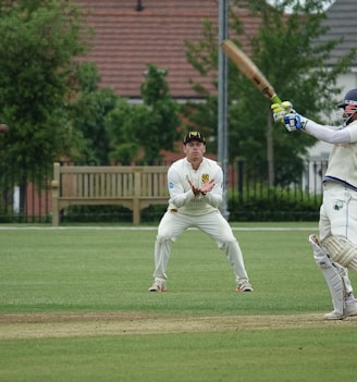 man in white jersey shirt and pants playing baseball during daytime