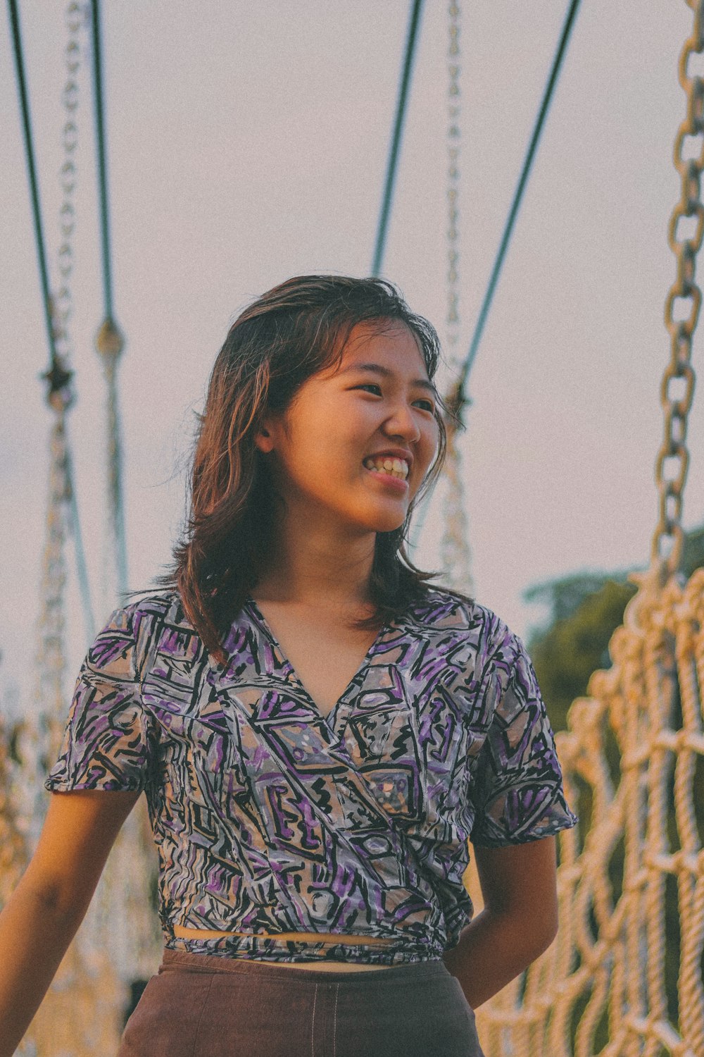 woman in black and white floral button up shirt standing near green plants during daytime