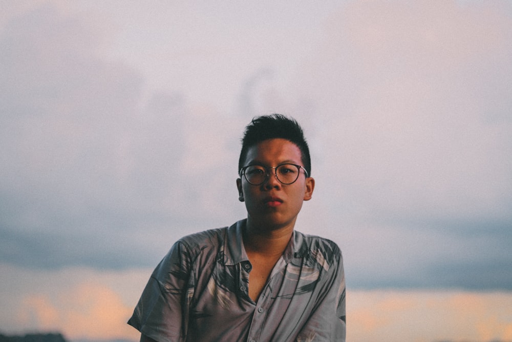 man in black framed eyeglasses and gray button up shirt