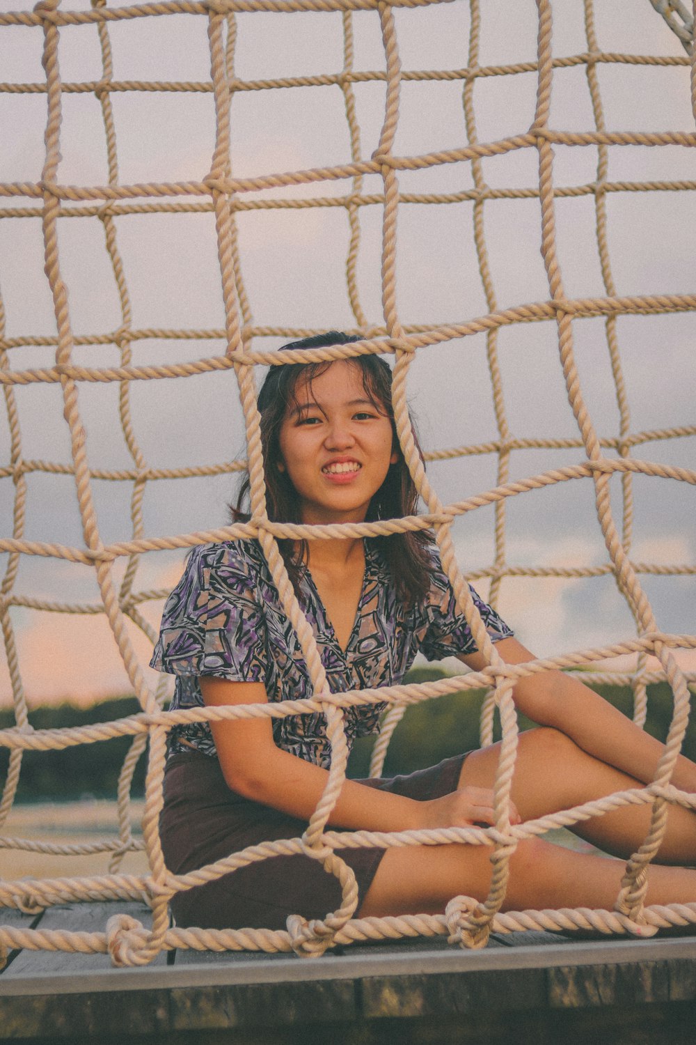 woman in blue and white shirt sitting on white net