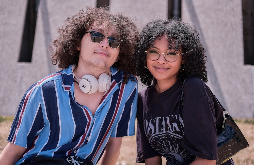 woman in black and white crew neck shirt beside woman in blue and white stripe shirt