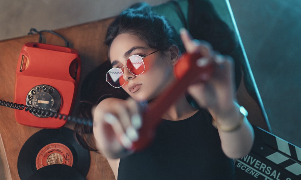 woman in black crew neck shirt holding red guitar