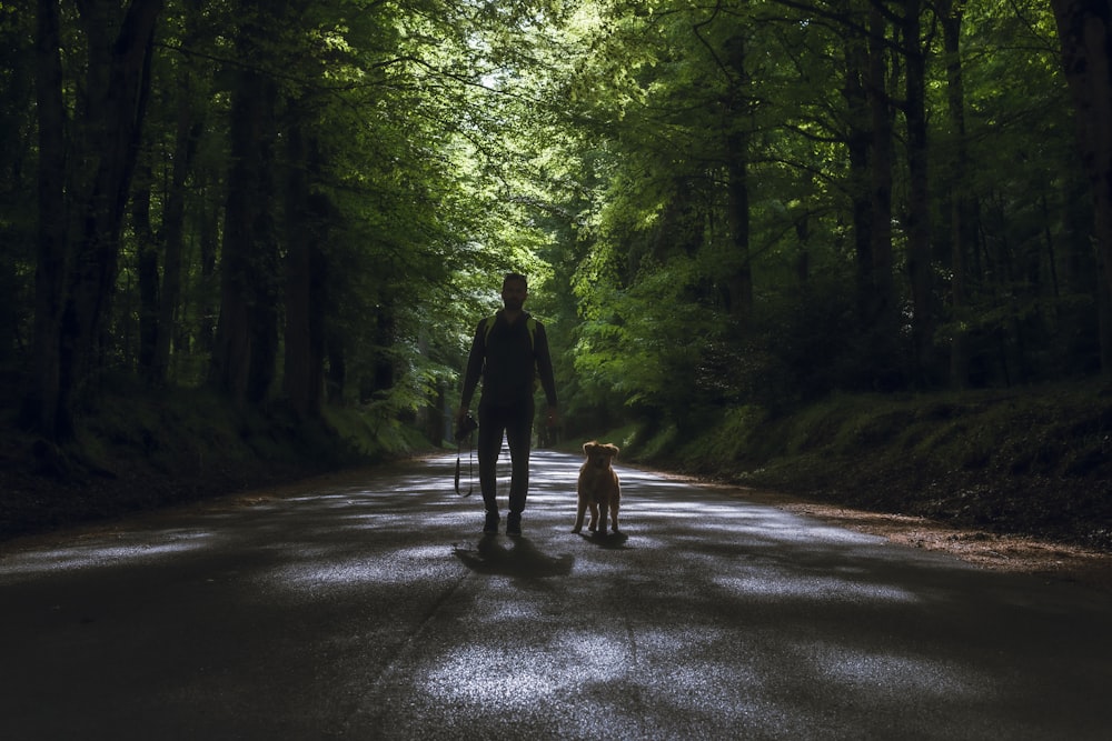 man in black jacket walking on road during daytime