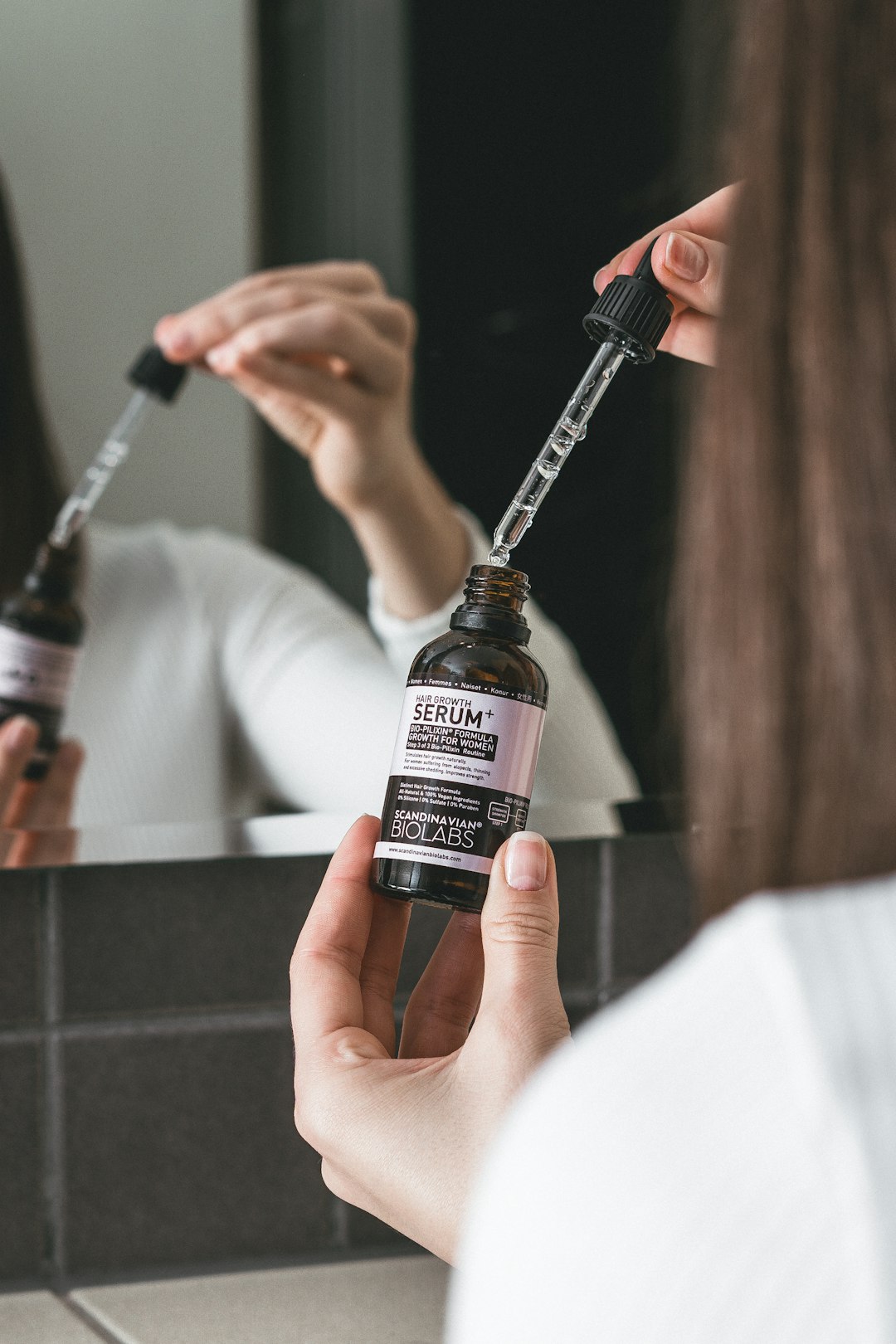 person holding black and white labeled bottle