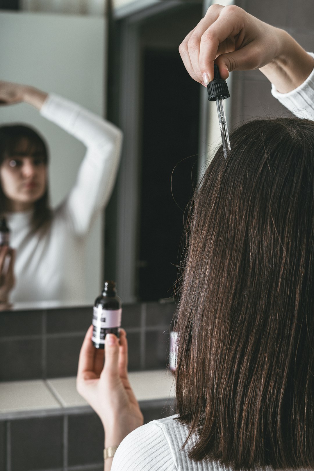 woman holding black and silver tube type vape