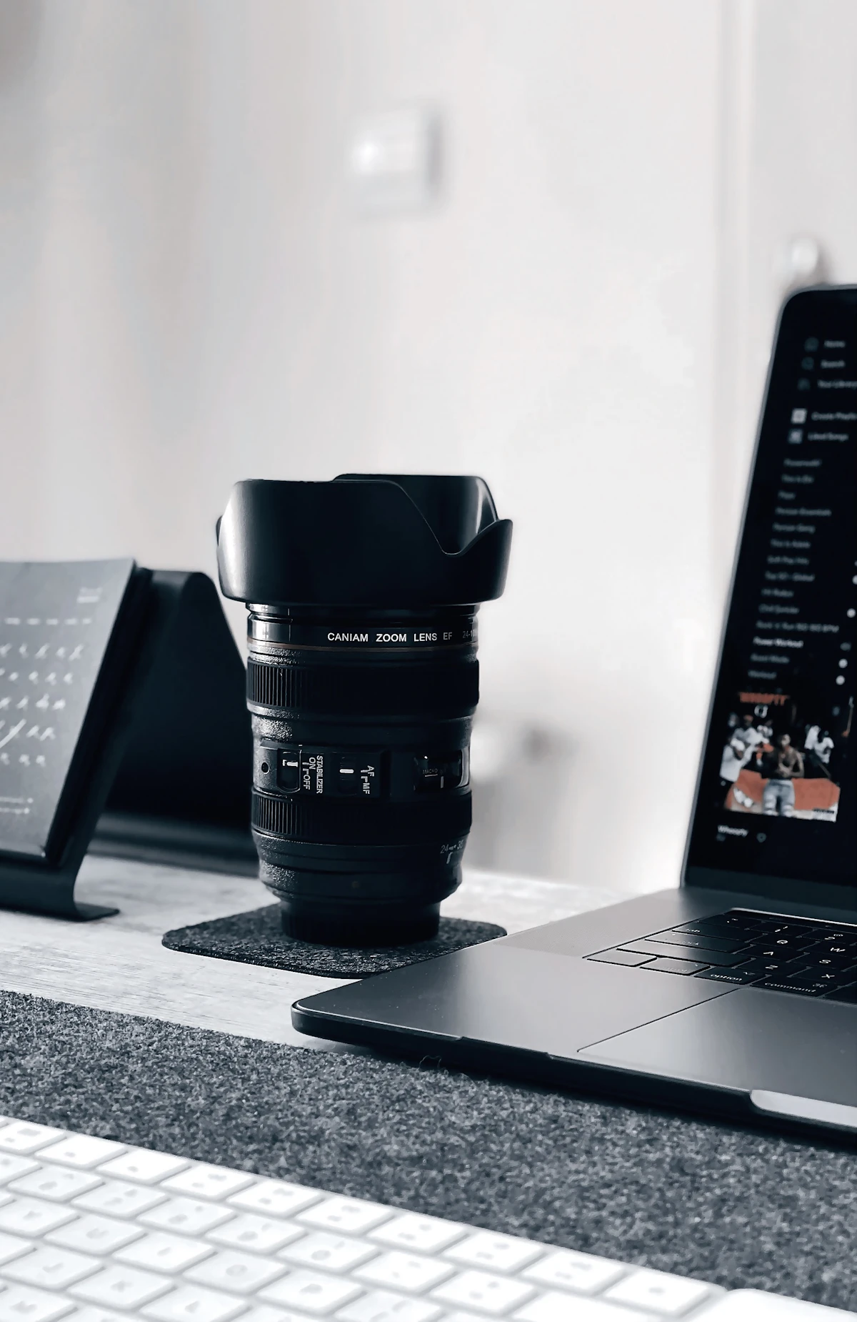 A camera lens resting on an open laptop