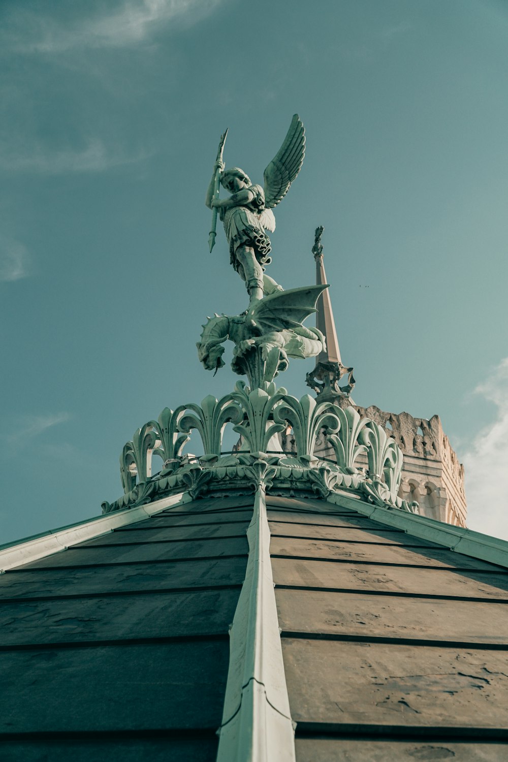 green and white statue of man on top of building