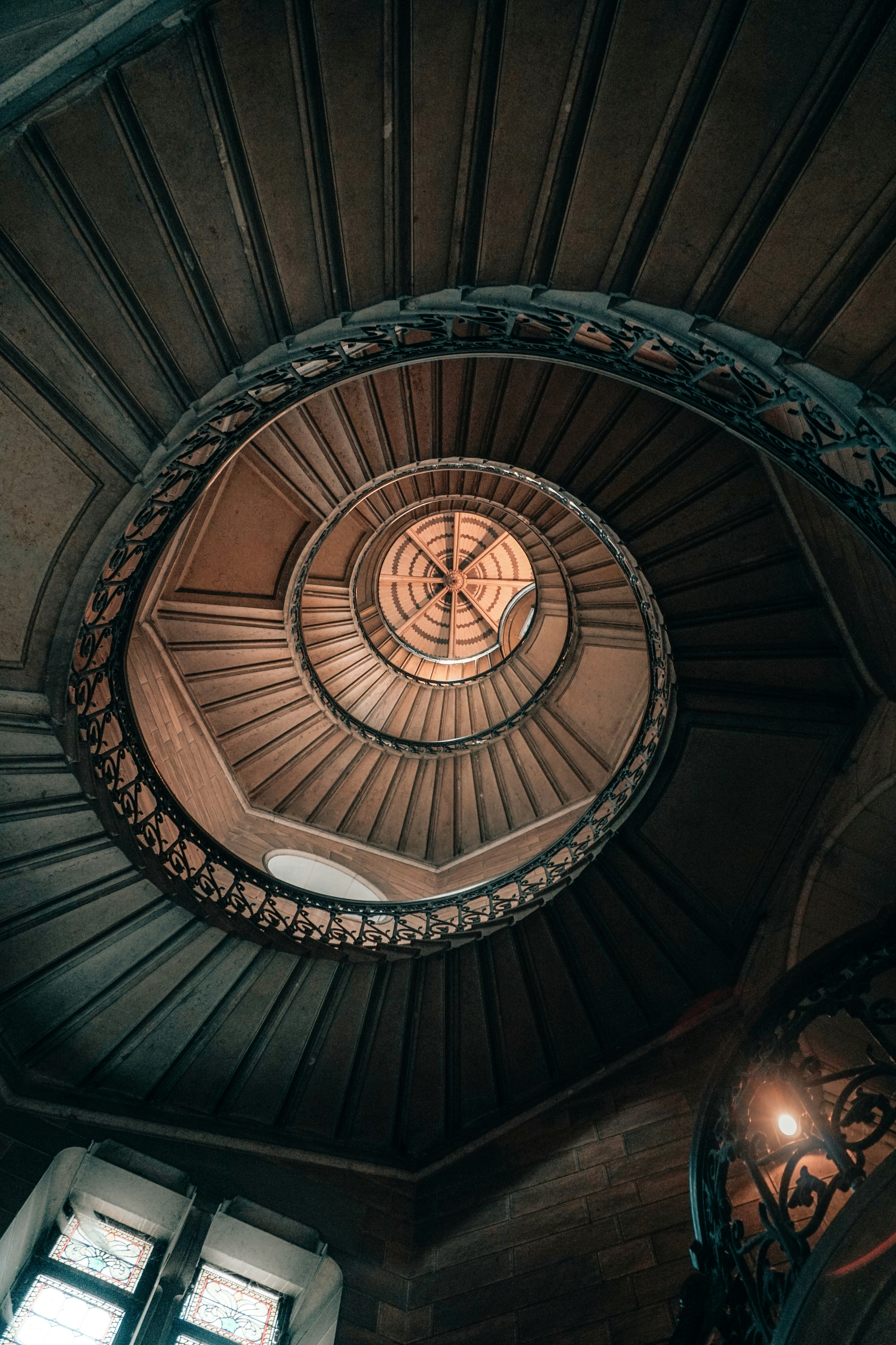 brown spiral staircase with brown wooden railings