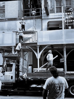 man in white crew neck t-shirt standing near white van during daytime