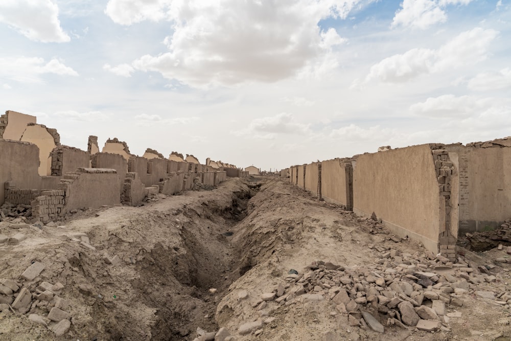 brown concrete wall under white clouds during daytime