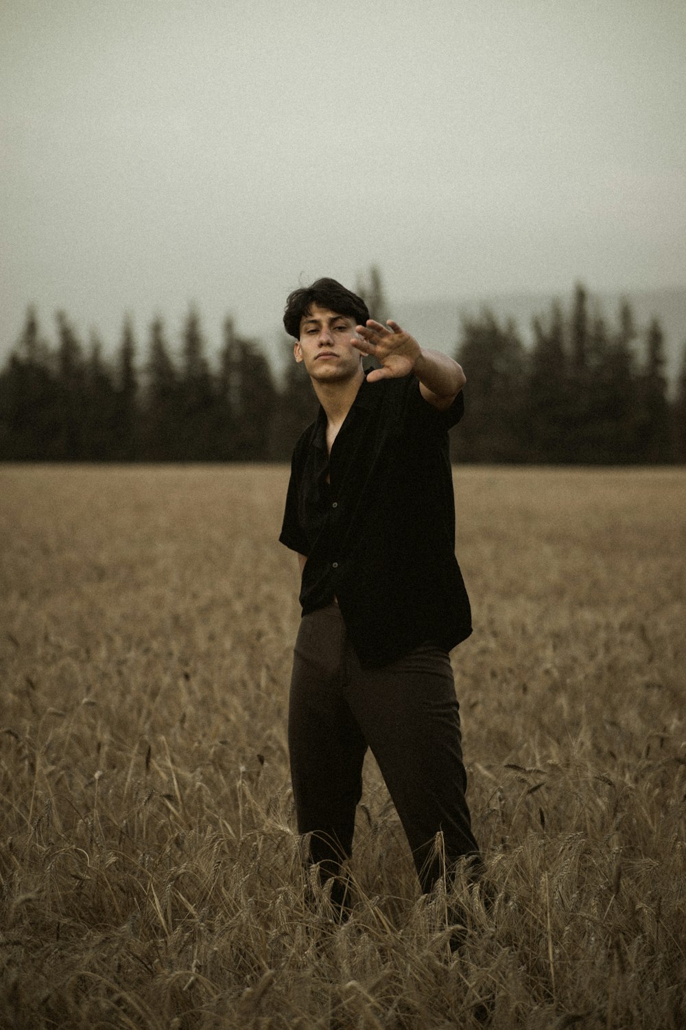 woman in black long sleeve shirt and black pants standing on grass field during daytime