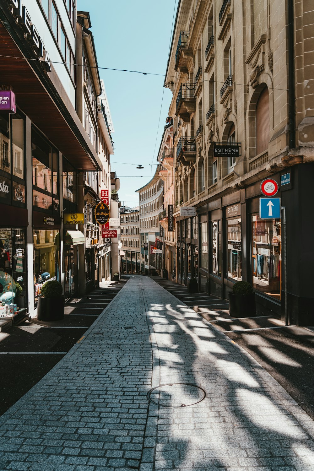 cars parked on sidewalk near buildings during daytime