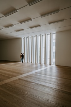 man in black t-shirt and black pants standing on brown wooden parquet floor
