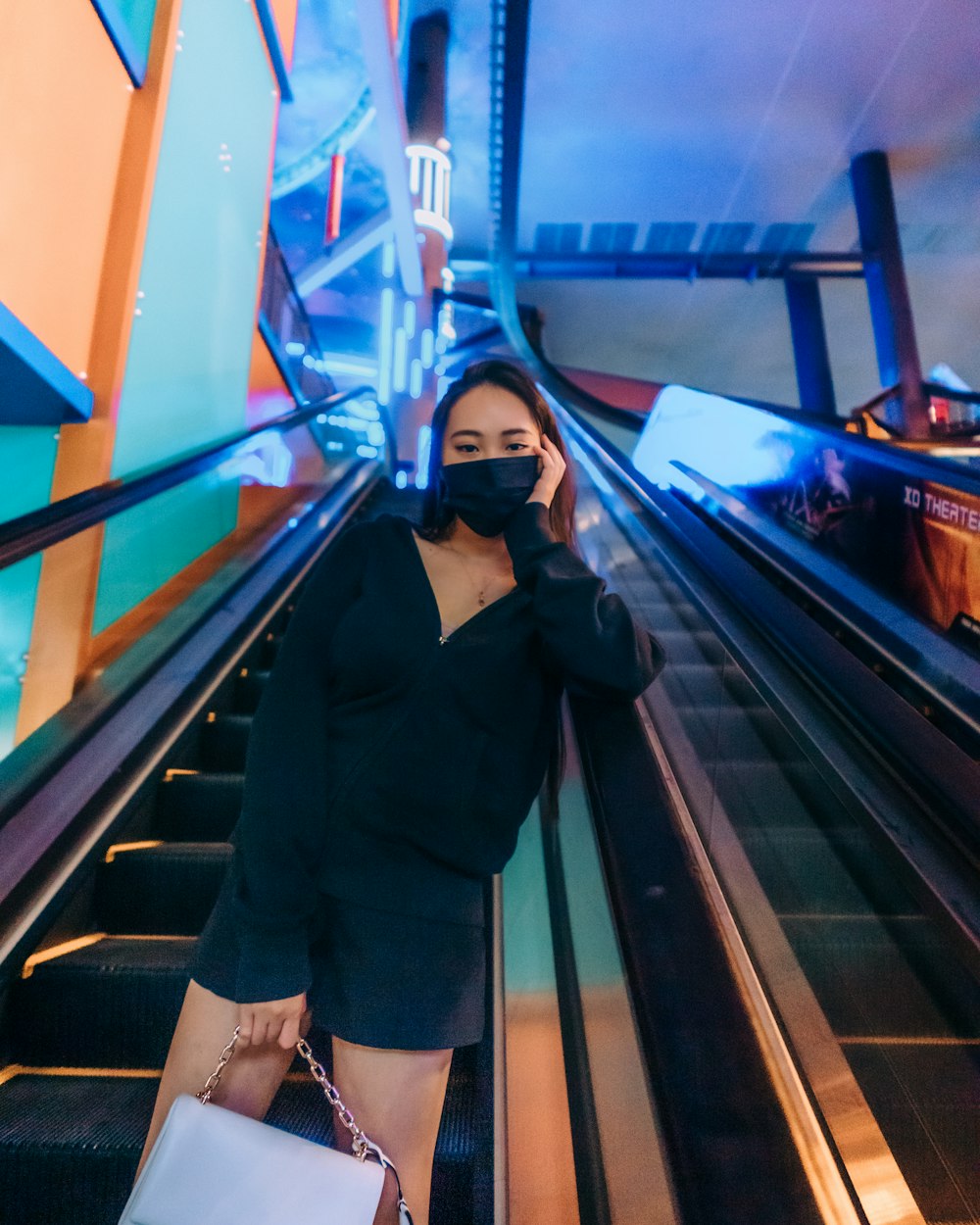 woman in black coat standing on escalator