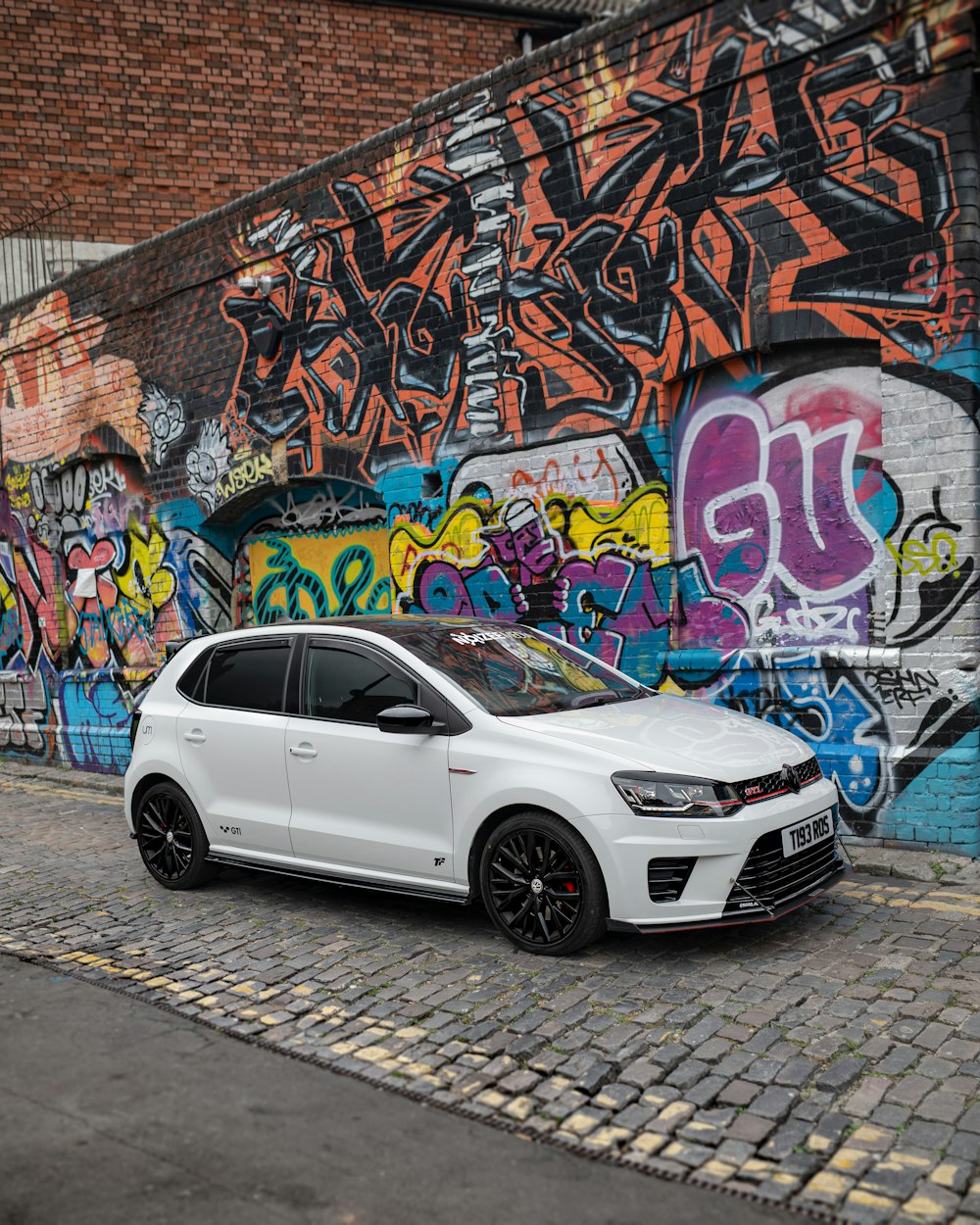 white mercedes benz suv parked beside blue and white graffiti wall