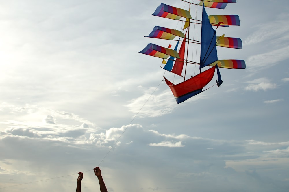 woman in black tank top holding yellow and blue striped umbrella under cloudy sky during daytime