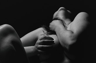 Artistic black and white photograph emphasizing body language and subtle shadows.