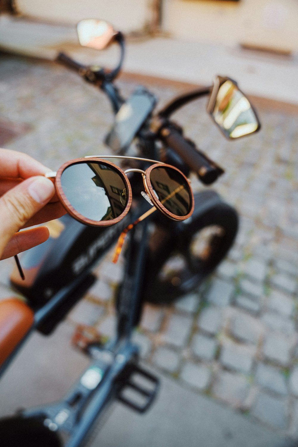 person holding black framed sunglasses