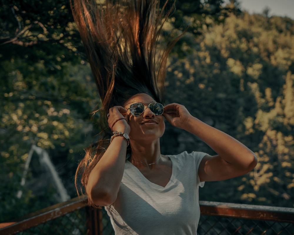 Mujer con camiseta blanca sin mangas con gafas de sol negras