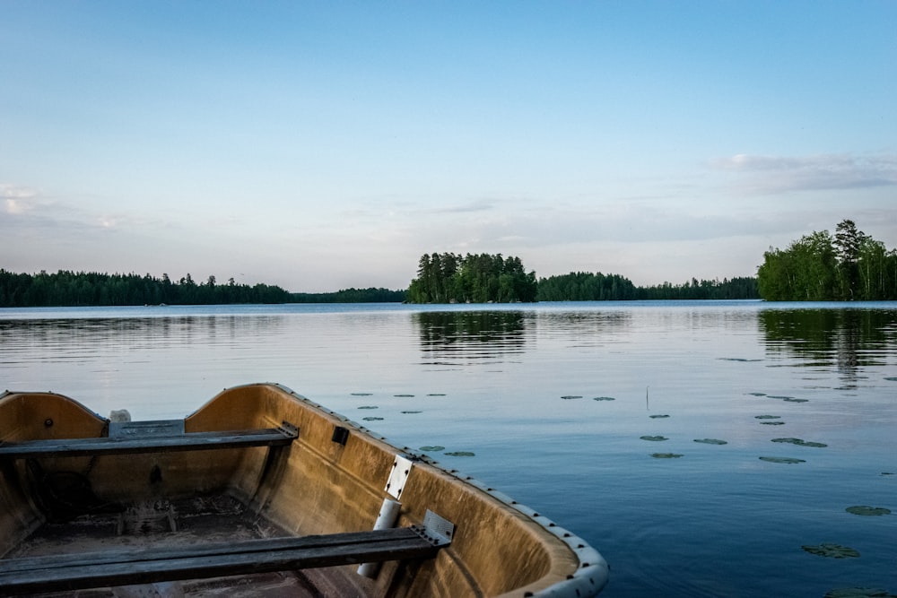 brown wooden boat on lake during daytime