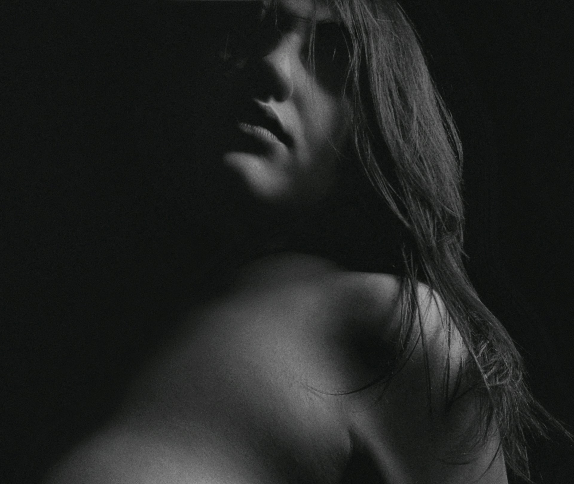 A striking black and gold portrait of a lone figure bathed in dramatic shadows, evoking mystery and elegance.